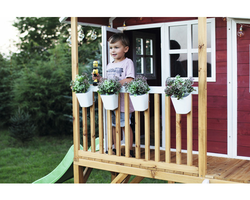 Dieťa v detskom domčeku so šmýkačkou a dekoráciou