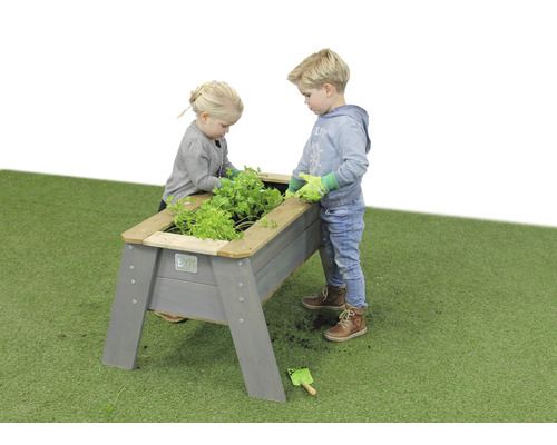 Dve deti záhradničí vo vyvýšenom drevenom záhone v záhrade.