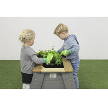 Deti sa hrajú s vyvýšeným záhonom v záhrade.