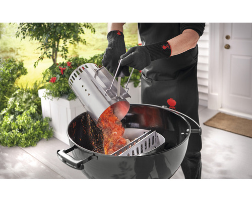 Osoba sype žeravé grilovacie uhlie z komína na zapaľovanie do grilu na drevené uhlie