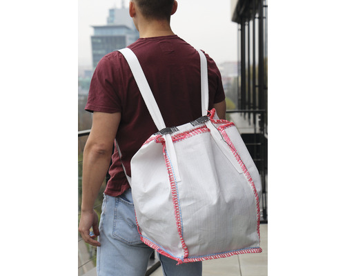 Osoba nesie na chrbte veľkoobjemové vrece.