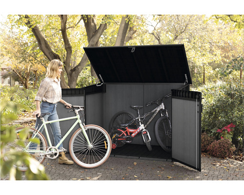 Box na bicykle s bicyklami a ženou v záhrade