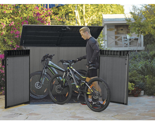 Plastový box na bicykle s dvoma bicyklami a jednou osobou v záhrade