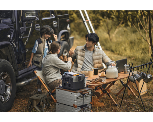 Rodinný kemp s prenosnou elektrárňou, stolom a príslušenstvom vedľa terénneho vozidla