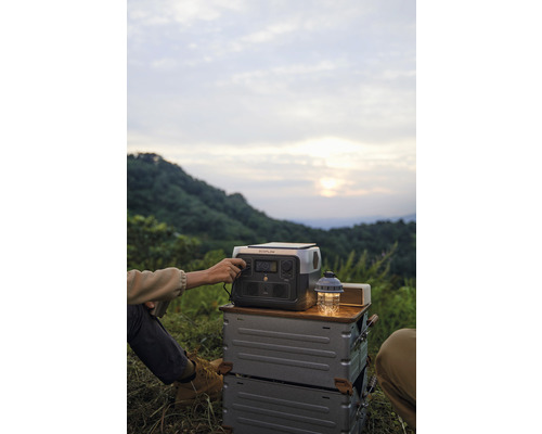 Osoba obsluhuje prenosnú napájaciu stanicu na kempingovom výlete