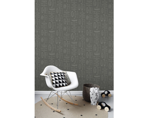 Pohľad do miestnosti s tapetou s grafickým vzorom, hojdacím kreslom a doplnkami