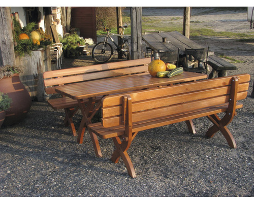 Záhradný nábytok so dreveným stolom a dvoma drevenými lavicami vonku.