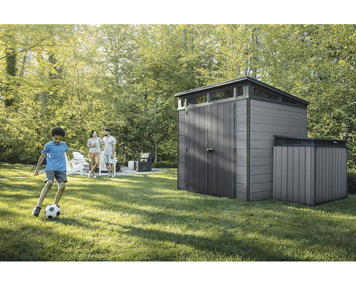 Záhradná scéna so záhradným domčekom a hrajúcim sa dieťaťom na trávniku