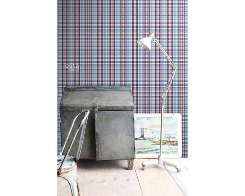 Scéna s kockovanou tapetou, kovovými prvkami, lampou a obrazom