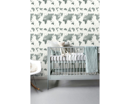 Detská izba so sivou tapetou s mapou sveta, detskou postieľkou a hojdacím kreslom