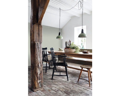 Jedáleň s dreveným stolom, stoličkami, drevenými trámami a závesnými svietidlami