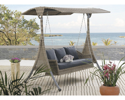 Záhradná hojdačka so strieškou, vankúše a plyšová hračka na terase s výhľadom na more