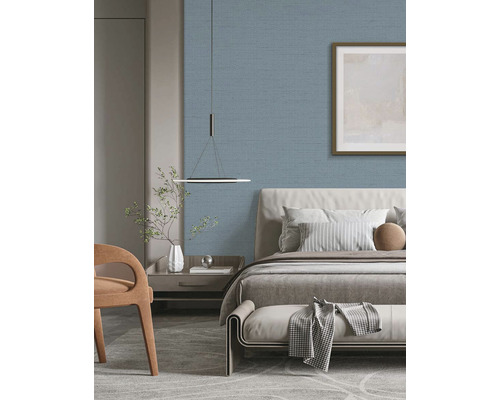 Spálňa s posteľou, nočným stolíkom a modrou textilnou tapetou