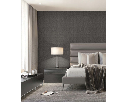 Spálňa s posteľou, nočným stolíkom, lampou a vzorovanou tapetou