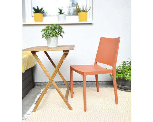 Záhradná scéna s dreveným stolom, plastovou stoličkou a izbovými rastlinami