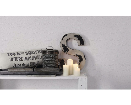 Dekoratívna scéna s vankúšom, nádobou, sviečkami a písmenom na poličke