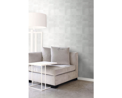 Obývacia izba so sivou vzorovanou tapetou, pohovkou, stolom a lampou