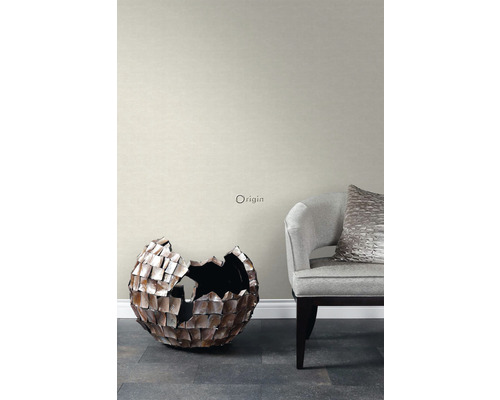 Obývacia izba so sivou tapetou, dekoratívnou guľou a kreslom.