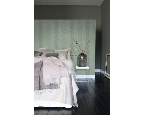 Moderná spálňa so vzorovanou tapetou, posteľou, príručným stolíkom a dekoráciou