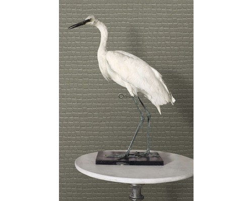 Dekoratívna figúrka volavky na podstavci na stole