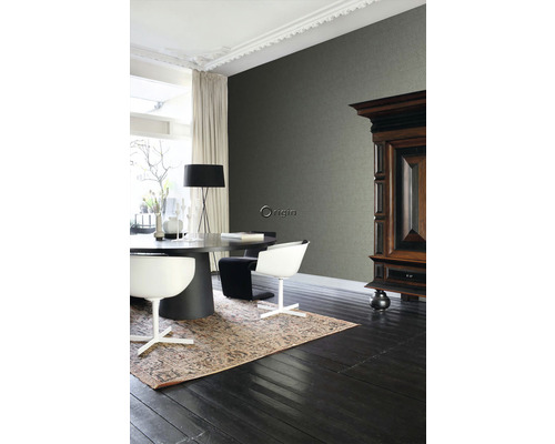 Interiérový pohľad s tmavou drevenou podlahou, kobercom, jedálenským stolom, stoličkami, komodou a vzorovanou tapetou.