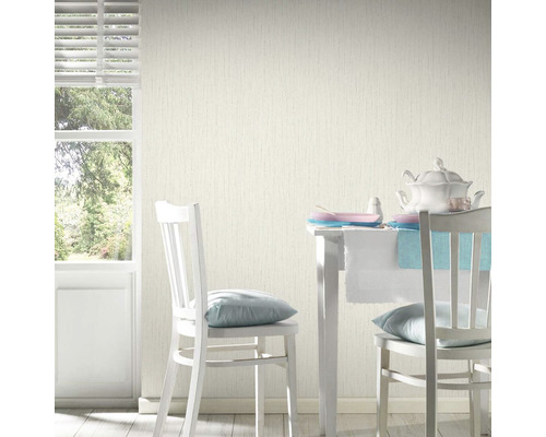 Svetlá miestnosť so vzorovanou tapetou, jedálenským stolom a stoličkami