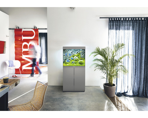 Obývacia izba s akváriom na skrinke, izbovou rastlinou a závesmi