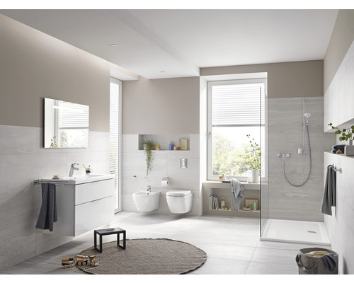 Svetlá kúpeľňa s umývadlom, zrkadlom, bidetom, toaletou a sprchou.