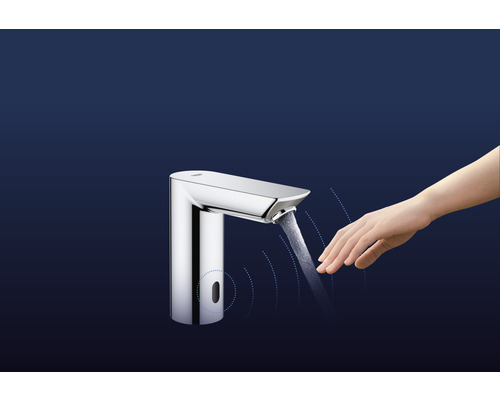 Vodovodný kohútik so senzorom a rukou pod tečúcou vodou