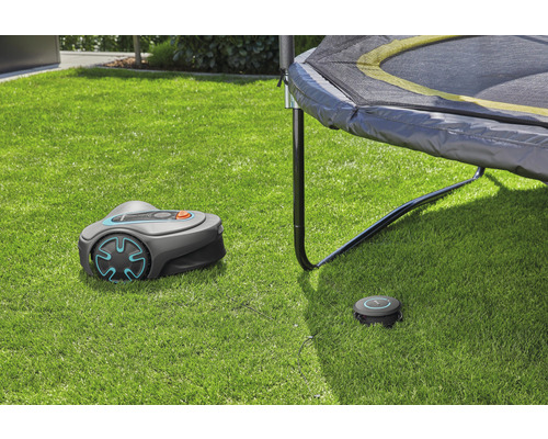 Robotická kosačka Gardena s nabíjacou stanicou na trávniku pod trampolínou
