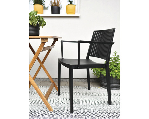 Čierna záhradná stolička s podrúčkami vedľa dreveného stola na terase
