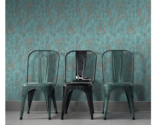 Scéna so vzorovanou tapetou a tromi kovovými stoličkami