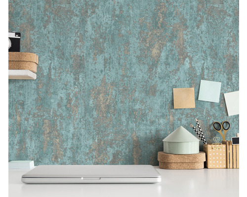 Scéna so štruktúrovanou tapetou, notebookom a kancelárskymi potrebami na bielom stole.