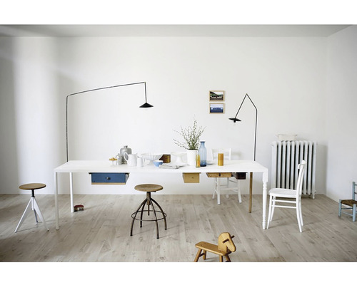 Svetlá miestnosť s veľkým jedálenským stolom, minimalistickými lampami a drevenými podlahami