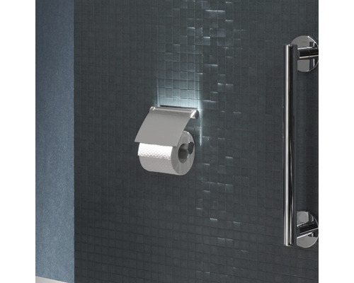 Toaleta s držiakom toaletného papiera a madlom na mozaikovej stene