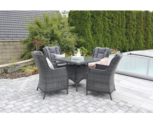 Záhradná scéna s ratanovým posedením so stolom a štyrmi stoličkami na terase.