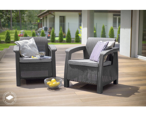 Dve sivé prútené kreslá s vankúšmi na terase.