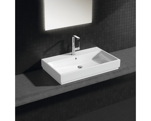 Obdĺžnikové keramické umývadlo s batériou na poličke v kúpeľni.