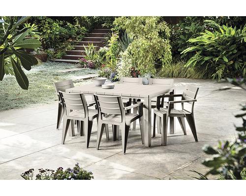 Štvorcový záhradný stôl s ôsmimi stoličkami na terase so záhradou