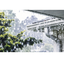 Dažďová voda steká zo strechy do odkvapu