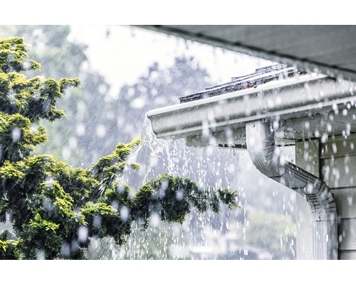 Dažďová voda steká zo strechy do odkvapu