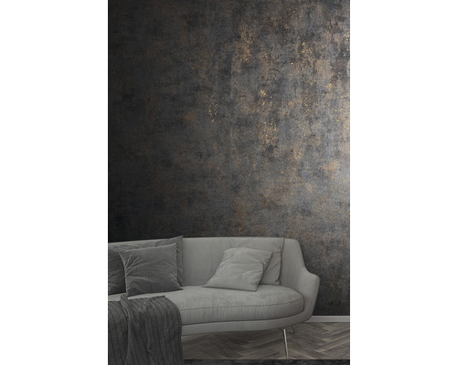 Obývacia izba so sivou pohovkou a tmavou štruktúrovanou tapetou so zlatými akcentmi.