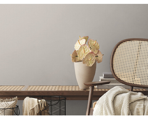 Dekoratívny interiér s lavicou, ratanovou stoličkou a antúriami vo váze