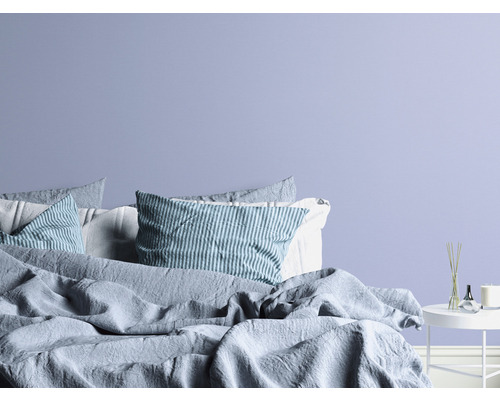 Spálňa s posteľou, vankúšmi a príručným stolíkom