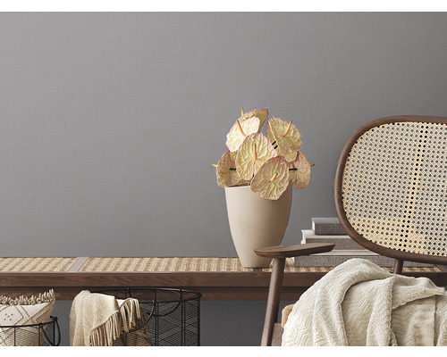 Dekoratívne zátišie s antúriami vo váze a ratanovou stoličkou