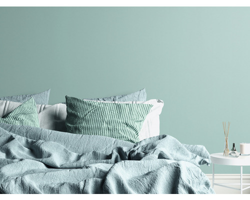 Spálňa s posteľou, vankúšmi a nočným stolíkom