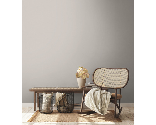 Obývacia izba s drevenou lavicou, kovovými košíkmi, dekoráciami, kobercom a hojdacím kreslom.