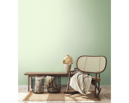 Svetlý, priateľský interiér s lavicou, ratanovým kreslom, košíkmi a dekoráciou na koberci.