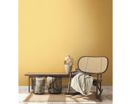 Obývacia izba s drevenou lavicou, prúteným hojdacím kreslom a dekoráciou