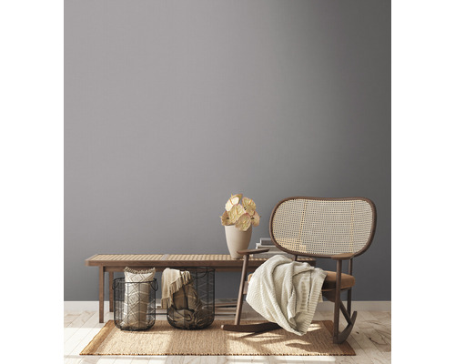 Obývacia izba s drevenou lavicou, dekoráciami, košíkmi a hojdacím kreslom na koberci.